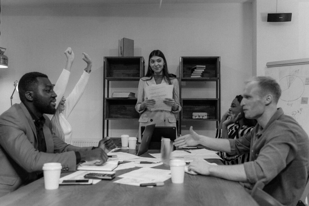 A diverse group of adults having an engaged business meeting indoors with teamwork and discussion.